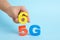 Man putting 6G instead 5G on light blue background, closeup