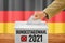 Man putting a ballot into a voting box - Parliamentary election 2021 in german - Bundestagswahl 2021