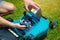 Man putting battery into electric cordless lawn mower