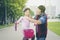 Man putting a bike helmet for his child at park