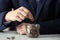 Man putting coin into jar at grey marble table. Money savings