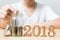 Man putting coin in jar with wood number 2018 year, Save money a