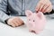 Man putting coin in piggy bank.