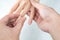 Man putting diamond ring on woman hand over white background