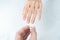 Man putting diamond ring on woman hand over white background