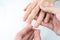 Man putting diamond ring on woman hand over white background