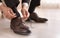 Man putting on elegant leather shoes indoors