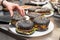 Man putting finished black burgers onto a plate