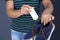 Man putting powder shoe freshener in footwear on color background