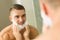 Man putting shaving foam on face