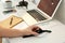 Man putting smartwatch onto wireless charger at table, closeup. Modern workplace accessory