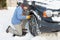 Man Putting Snow Chains Onto Tyre Of Car