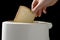 Man putting white bead slices in toaster