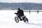 Man racing dirt bike on frozen pond