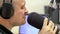 Man radio DJ speaks into microphone close-up