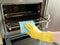 Man with rag cleaning kitchen stove