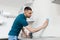 Man with rag cleaning wall at home kitchen