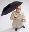 Man in raincoat holding umbrella checking for rain