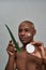 Man raising aloe plant and cream in both hands