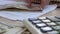 Man rake up dollar banknotes on an office desk.