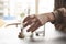 Man reaches out for a bottle of alcohol and an empty glass by the side at a table in home or bar environment. Selective focus on h