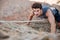 Man reaching for a grip while he rock climbs