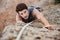 Man reaching for a grip while he rock climbs