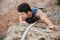 Man reaching for a grip while he rock climbs