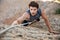 Man reaching for a grip while he rock climbs