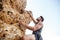 Man reaching for a grip while he rock climbs