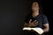 Man reading a bible isolated on black.