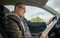 Man is reading a book while driving a car and is distracted