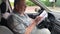 Man reading book while sitting inside of passenger car on driver seat