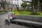 Man reading a newspaper in a bench in a park in the Independence Square at the city of Quito, in Ecuador