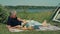 A man reads a book while relaxing in nature in the summer.