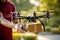 A man receives or sends a delivery by drone. Delivery in a cardboard box