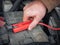 Man recharging a dead car battery in winter time using start-charger. Close up hands of a man with two contact clips