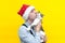 Man in red christmas santa hat, blue shirt and black suspender hug and kiss cute white with grey tabby cat