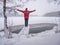 Man in red dark clothes  standing on the winter snowy bank