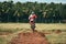 Man in red motorcycle apparel joyfully riding a motorcycle on a dirt road