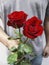 A man with red roses and valentine in the hands.