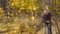 Man with red roses waiting for his beloved woman on a date in the autumn forest