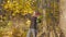 Man with red roses waiting for his beloved woman on a date in the autumn forest