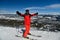 Man in red ski suit standing on the top of Breckenridge ski resort.