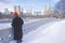 Man Red stocking cap looks at pond in fresh snow in Central Park, Manhattan, New York City, NY