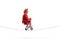 Man in a red suit riding a small red bike on a rope