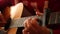 A man in a red sweater plays an acoustic guitar indoors a close-up view of an wide open aperture