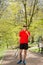 The man in a red t-shirt pose with a tennis racket and a ball on the background of green park. Sport concept