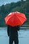 Man with red umbrella contemplates on rain