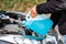 Man refills windshield wiper water on a car